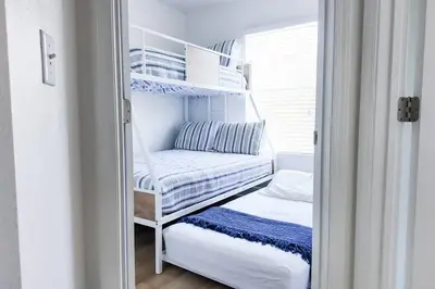a room with two bunk beds and a window at Walk to Rosemary - Poolside, 6 Bikes, Beach Access in Inlet Beach