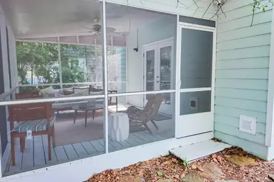 a screened in porch with a table and chairs at Walk to Rosemary - Poolside, 6 Bikes, Beach Access in Inlet Beach