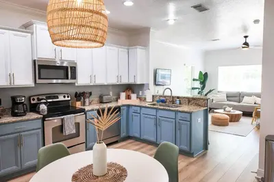 a kitchen with blue cabinets and a table in a room at Walk to Rosemary - Poolside, 6 Bikes, Beach Access in Inlet Beach