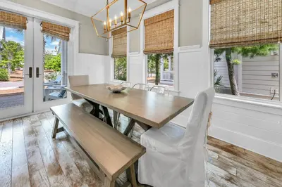 a dining room with a wooden table and chairs at Town of Prominence- Just Beachy in Inlet Beach
