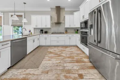a kitchen with white cabinets and stainless steel appliances at Town of Prominence- Just Beachy in Inlet Beach