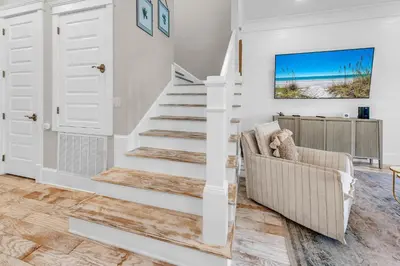 a white staircase in a living room with a couch at Town of Prominence- Just Beachy in Inlet Beach