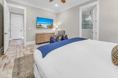 a white bedroom with a bed and a tv at Town of Prominence- Just Beachy in Inlet Beach