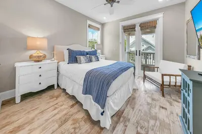 a bedroom with a bed and a dresser and a window at Town of Prominence- Just Beachy in Inlet Beach
