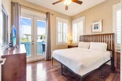 a bedroom with a bed and a tv and windows at Ta-Da! Luxury 2BR Townhome, Golf Cart & Pool Access in Santa Rosa Beach
