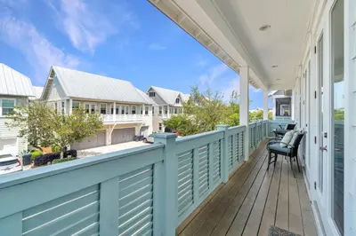 a porch with a blue fence and a chair at Ta-Da! Luxury 2BR Townhome, Golf Cart & Pool Access in Santa Rosa Beach
