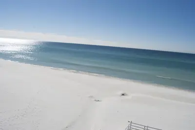 a beach with the ocean and a fence on it at Casa Loma Panama City Beach - Beachfront in Panama City Beach