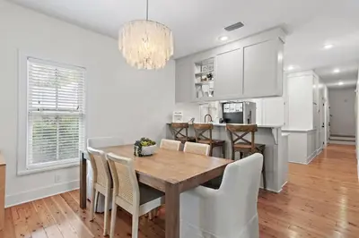a kitchen and dining room with a wooden table and chairs at Steps to Public & Private Beach in Seacrest FL 30A, Pool, Bikes, Gear, and More! in Seacrest