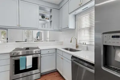 a kitchen with white cabinets and stainless steel appliances at Steps to Public & Private Beach in Seacrest FL 30A, Pool, Bikes, Gear, and More! in Seacrest