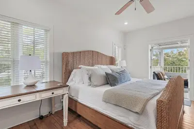 a bedroom with a bed and a desk and windows at Steps to Public & Private Beach in Seacrest FL 30A, Pool, Bikes, Gear, and More! in Seacrest