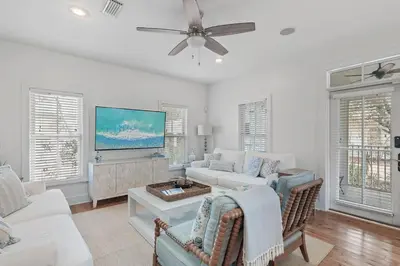 a living room with white furniture and a flat screen tv at Steps to Public & Private Beach in Seacrest FL 30A, Pool, Bikes, Gear, and More! in Seacrest