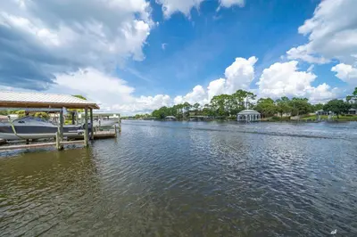 a boat docked at a dock on a river at Dolphin Days Lagoon Retreat in Panama City Beach