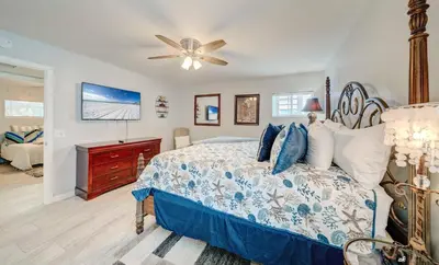 a bedroom with a bed and a ceiling fan at Dolphin Days Lagoon Retreat in Panama City Beach