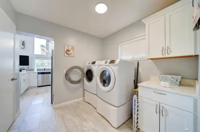 a laundry room with a washer and dryer in it at Dolphin Days Lagoon Retreat in Panama City Beach