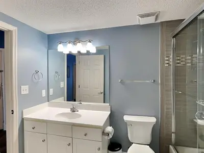 a bathroom with a sink and a toilet and a mirror at Majestic Beach Towers I #2302 in Panama City Beach