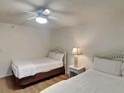 a bedroom with two beds and a ceiling fan at Edgewater Tower III #1210 in Panama City Beach