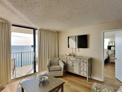 a living room with a room with a balcony at Edgewater Tower III #1210 in Panama City Beach
