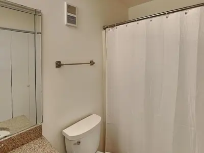 a bathroom with a white toilet and a shower at Edgewater Tower III #1210 in Panama City Beach