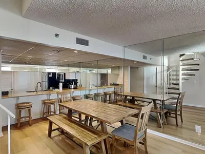 a dining room with wooden tables and chairs at Edgewater Tower III #1210 in Panama City Beach
