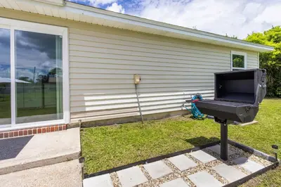 a tv on a stand in front of a house at Charming 3BR Home with Free Parking & Game Room in Panama City