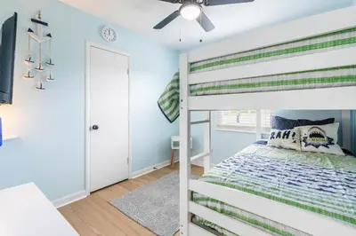 a bedroom with a bunk bed and a ceiling fan at Charming 3BR Home with Free Parking & Game Room in Panama City