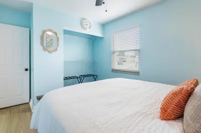 a blue bedroom with a bed and a clock on the wall at Charming 3BR Home with Free Parking & Game Room in Panama City