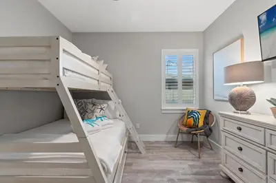a bedroom with a bunk bed and a desk at Charming 3/2 Beach House w/ POOL & Golf Cart INCLUDED - 1 Min Walk to Beach in Panama City Beach