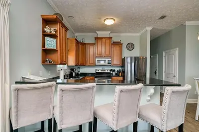 a kitchen with a counter with chairs around it at Vista del Mar I Short Walk to the Beach 301 in Panama City Beach