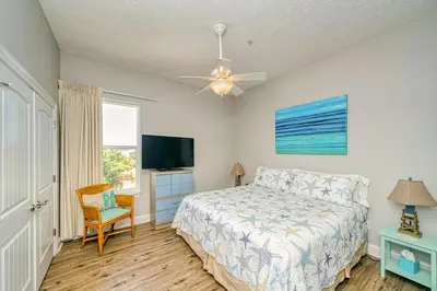 a bedroom with a bed and a flat screen tv at Vista del Mar I Short Walk to the Beach 301 in Panama City Beach