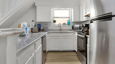 a kitchen with white cabinets and a stainless steel refrigerator at Eastern Shores 215 in Santa Rosa Beach