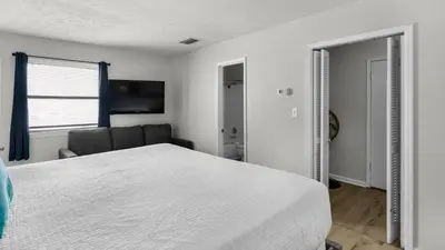 a bedroom with a white bed and a chair at Eastern Shores 215 in Santa Rosa Beach