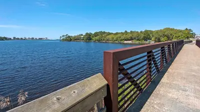 a wooden bench sitting on a pier next to the water at Eastern Shores 215 in Santa Rosa Beach