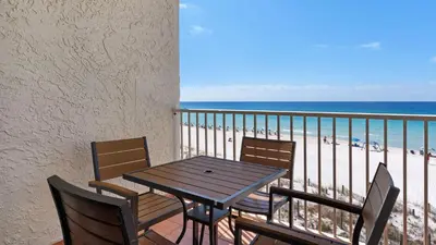 a table and chairs on a balcony with the beach at Eastern Shores 215 in Santa Rosa Beach
