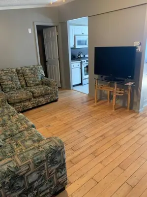 a living room with a couch and a flat screen tv at Double Wide Getaway in PCB in Panama City Beach