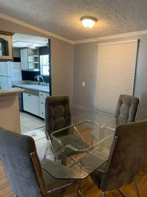 a living room with a glass table and chairs at Double Wide Getaway in PCB in Panama City Beach