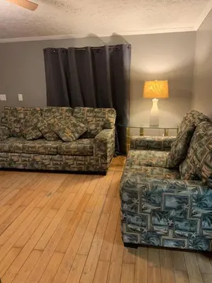 a living room with a couch and a chair at Double Wide Getaway in PCB in Panama City Beach