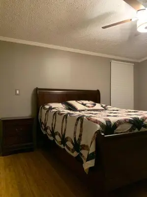 a bedroom with a bed with a blanket on it at Double Wide Getaway in PCB in Panama City Beach