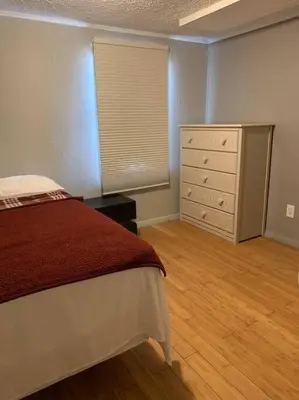 a bedroom with a bed and a dresser and a window at Double Wide Getaway in PCB in Panama City Beach