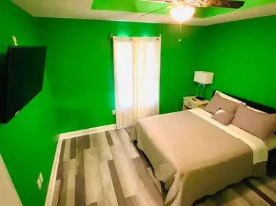 a green bedroom with a bed and a green wall at Newly renovated modern, spacious & quiet location in Callaway