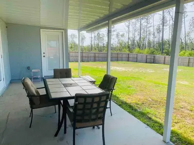 a porch with a table and chairs on a patio at Newly renovated modern, spacious & quiet location in Callaway