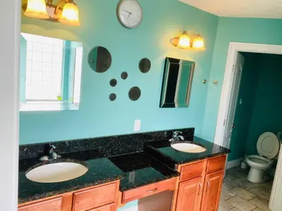 a bathroom with two sinks and a clock on the wall at Newly renovated modern, spacious & quiet location in Callaway