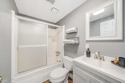 a white bathroom with a toilet and a sink at Dolphin's Den in Panama City Beach