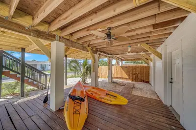 a house with two kayaks sitting on a deck at Dolphin's Den in Panama City Beach