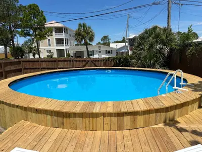 a large swimming pool with a wooden deck around it at Dolphin's Den in Panama City Beach