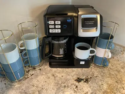 a coffeemaker with cups and coffee cups at Dolphin's Den in Panama City Beach