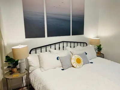 a bedroom with a bed with white sheets and pillows at Dolphin's Den in Panama City Beach