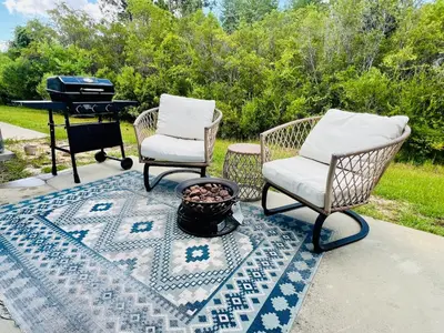 a patio with two chairs and a grill and a rug at Close to beach, Pier Park, Game Room Theater Room in Panama City Beach