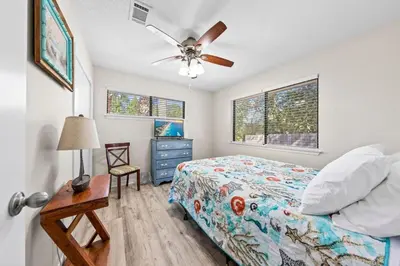 a bedroom with a bed and a ceiling fan at Beachcombers Nook, Firepit, yard, Sleeps 8, Walk to Beach in Panama City Beach