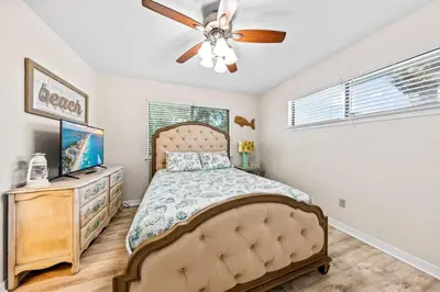a bedroom with a bed and a ceiling fan at Beachcombers Nook, Firepit, yard, Sleeps 8, Walk to Beach in Panama City Beach
