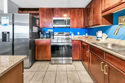 a kitchen with wooden cabinets and a stainless steel refrigerator at Laketown Wharf 927 in Panama City Beach